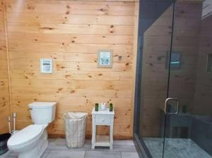 a wooden bathroom with a toilet and a shower at The Grand Tennessean Cabin- Four Bedroom Luxury Cabin in the Mountains in Pigeon Forge