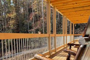 a wooden porch with a chair and a large window at The Grand Tennessean Cabin- Four Bedroom Luxury Cabin in the Mountains in Pigeon Forge