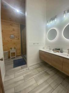 a bathroom with a sink and a mirror at The Grand Tennessean Cabin- Four Bedroom Luxury Cabin in the Mountains in Pigeon Forge