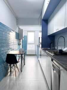 a kitchen with a table and a blue wall at Apartament Vivo & Pool access - Free parking in Constanţa