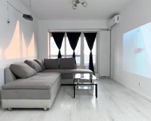 a living room with a couch and a table at Apartament Vivo & Pool access - Free parking in Constanţa