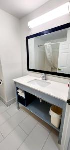 La salle de bains est pourvue d'un lavabo et d'un miroir. dans l'établissement Baymont by Wyndham Port Wentworth, à Port Wentworth