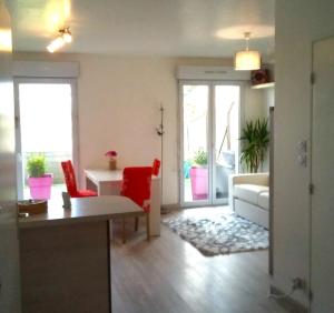 a living room with a couch and a table and chairs at Appartement calme rez-de-jardin in Saint-Étienne