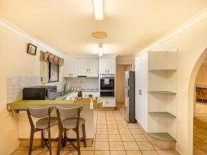 a kitchen with white cabinets and a table and chairs at Steps from Mall Super Convenient 3BR Cozy House in Brisbane