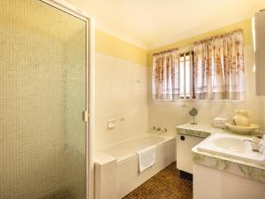 a bathroom with a tub and a sink and a shower at Steps from Mall Super Convenient 3BR Cozy House in Brisbane