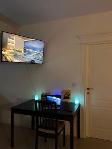 einen Schreibtisch mit Stuhl und einen TV an der Wand in der Unterkunft A quiet place - AB Homes - ap 3 rooms Netflix&chill in Iaşi