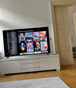 a large flat screen tv sitting on top of a white cabinet at Byt ve městě Praha 2 in Prague