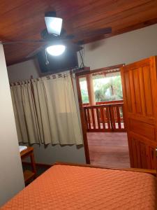um quarto com uma cama, uma ventoinha de tecto e uma janela em Cabañas y Mirador El Pericón em Arambala
