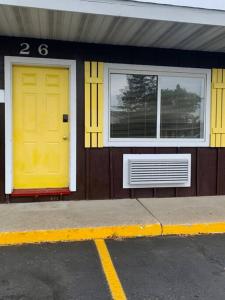 ein Haus mit gelber Tür und zwei Fenstern in der Unterkunft #26 Snooze in Wisconsin Rapids