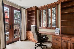 アスペンにある315 Park Avenue, Luxury Townhouse with River Views in Aspenの木製のキャビネットのある部屋にある机と椅子