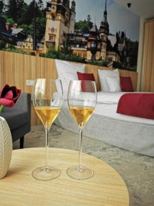 two glasses of white wine sitting on a table at YMY Boutique Residence in Bucharest