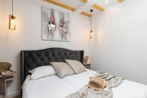a bedroom with a bed with a black headboard at Nono's House I in Dubrovnik