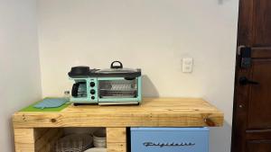 a blue toaster oven sitting on top of a wooden table at DGM Lofts MTY MN 960 A centro cerca de todo in Monterrey
