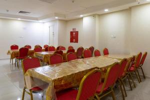 a conference room with long tables and red chairs at فندق المسار أجياد - ALMASAR AJIAD HOTEL in Makkah