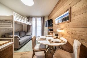 シャモニー・モンブランにあるEden Studio Chamonix Centreのテーブルと二段ベッド付きの小さな部屋です。
