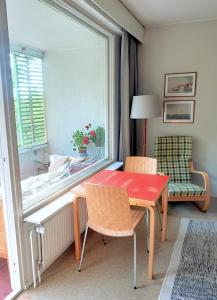 トゥルクにあるPeaceful apartment on Sofiankatu Turku Centerの赤いテーブルと椅子、窓が備わる客室です。
