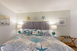 a bedroom with a bed with pillows and stars on the wall at 202 - Sandy Shores in St. Pete Beach