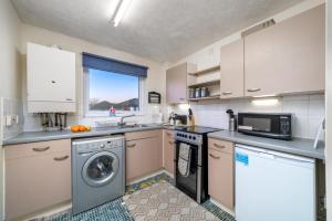 cocina con lavadora y microondas en Cozy Apartment in Greater London – 1BR,1 Bath en Londres