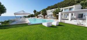 a villa with a swimming pool and a house at Ionian Green in Kefalári
