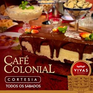 een chocoladetaart met aardbeien bovenop op een tafel bij Vivas Hotel e Casa in Monte Sião