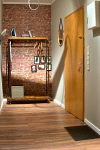 a hallway with a brick wall and a wooden door at Industrial Style 77qm mit Balkon in Herne