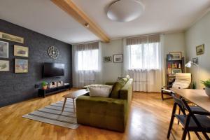 a living room with a couch and a television at Serene 1BR with Sauna & Private Entrance in Tallinn