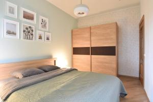 a bedroom with a large bed and a large wooden cabinet at Serene 1BR with Sauna & Private Entrance in Tallinn