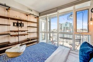 1 dormitorio con cama y ventana grande en Beautiful Condos By CN Tower en Toronto