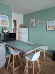 a kitchen with a table and chairs in a room at Studio Calais Front de mer-Le Cocon du Dragon-Classé 3 etoiles in Calais