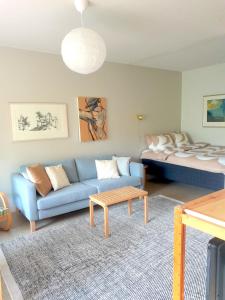 a living room with a blue couch and a bed at Peaceful apartment on Sofiankatu Turku Center Free parking in Turku