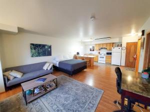 a living room with a blue couch and a kitchen at Downtown Juneau Gem: 1BR Apt with Stunning Views! in Juneau