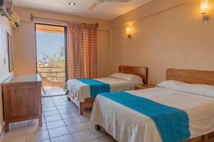 una camera d'albergo con due letti e una finestra di Hotel El Mirador a Puerto Escondido