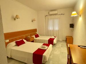 Cette chambre comprend deux lits et une télévision. dans l'établissement Hotel Puerto de Palos (La Rabida), à Palos de la Frontera