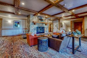 una sala de estar con sofás y una chimenea de piedra. en EagleRidge Lodge and Townhomes, en Steamboat Springs