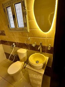 a bathroom with a toilet and a sink and a mirror at Pyramids Serenity in Cairo