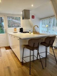 a kitchen with a sink and two chairs in it at Chalet 190 La Belle Durbuy in Durbuy