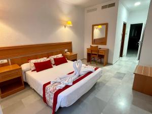 - une chambre avec un lit et une robe dans l'établissement Hotel Puerto de Palos (La Rabida), à Palos de la Frontera