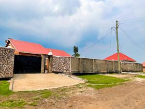 um edifício com um telhado vermelho e uma cerca em Agape House em Kisoro