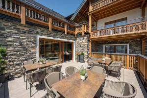 an outdoor patio with wooden tables and chairs at Hotel Haus Lungau in Mauterndorf