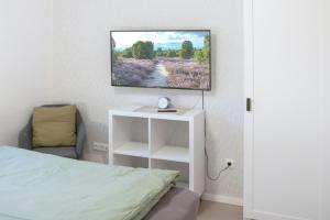 a bedroom with a bed and a tv on the wall at Ferienwohnung Wipperau II in Uelzen