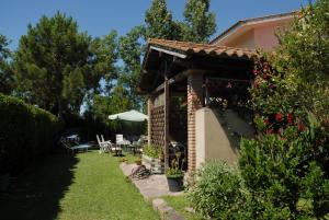 a house with a garden with a table and an umbrella at B&B Fra e Fe in Arborea