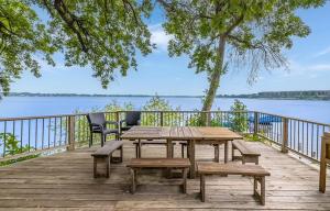 a wooden deck with a picnic table and chairs at The Lakeside Lookout on Gingles Point in Arnolds Park