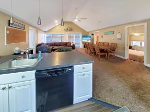 a kitchen with a sink and a living room at The Lakeside Lookout on Gingles Point in Arnolds Park +40 photos