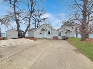 a white house with a driveway in front of it at The Lakeside Lookout on Gingles Point in Arnolds Park