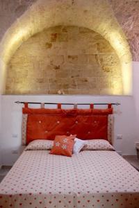 a bed in a room with a brick wall at Trulli Sulla Valle in Locorotondo