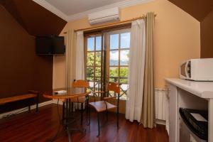 a small kitchen with a table and a window at Hotel Inti Kuyen Plaza in Pucón