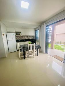 cocina con mesa y nevera blanca en Residencial Mariano 4 - Vista para praia e Mar en Florianópolis