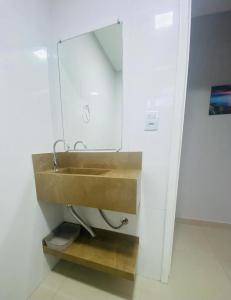 y baño con lavabo de madera y espejo. en Residencial Mariano 4 - Vista para praia e Mar en Florianópolis