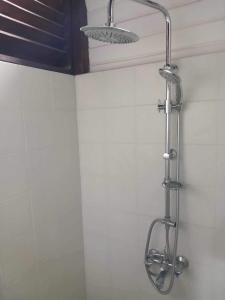 y baño con ducha y cabezal de ducha. en Great House BY Manaeva Lodge en Temae