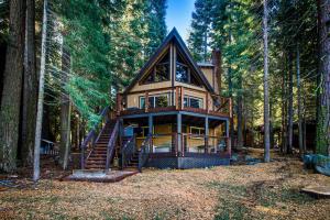 a tree house in the woods with a staircase at Donner Lakefront Retreat in Truckee